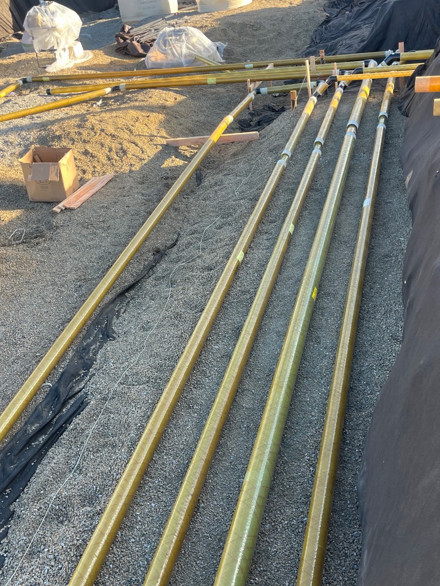 Close view of fiberglass product piping lines laid on gravel bedding