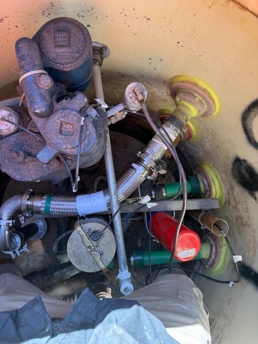 Inside a tank sump: submersible pump head, flexible connectors, piping and fittings