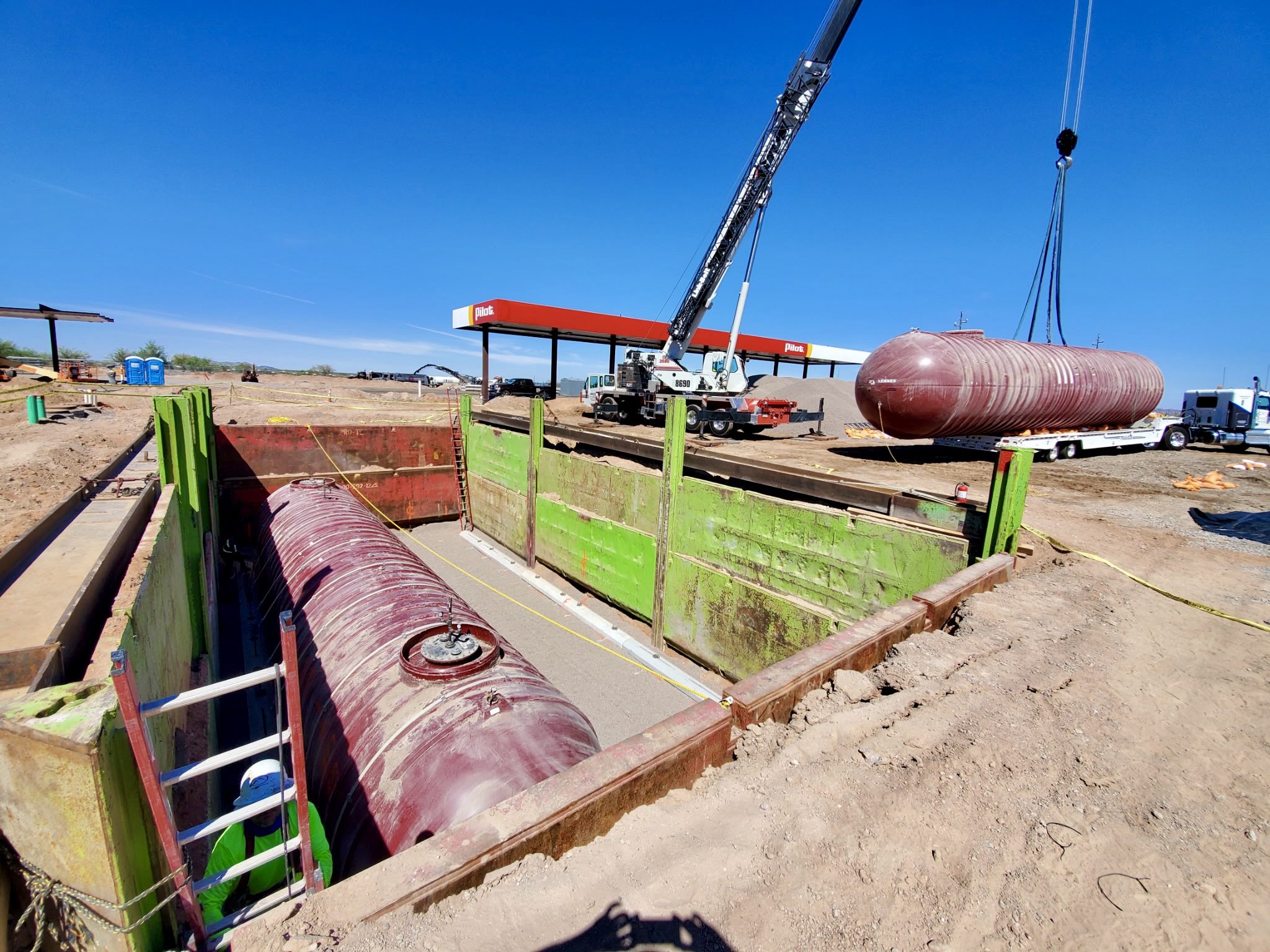 Underground fuel tanks being lowered into place by crane at a Vasquez jobsite