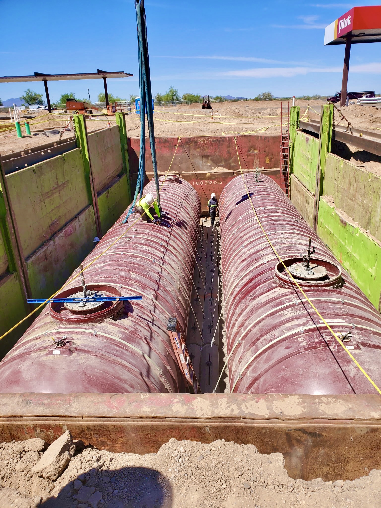 Vasquez crew and crane lowering underground fuel tanks into place at a Pilot travel center jobsite